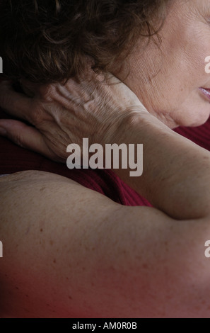 A woman messaging a sore spot on her body. Stock Photo