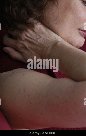 A woman messaging a sore spot on her body. Stock Photo