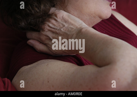 A woman messaging a sore spot on her body. Stock Photo