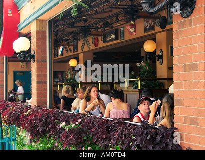 Tourists enjoying a meal at a sidewalk restaurant near Niagara Falls, Canada, with a bustling atmosphere and scenic surroundings. Stock Photo