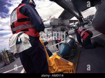 RAF armourers bomb up a Harrier GR7 of 1 Sqn RAF on the Royal Navy aircraft carrier HMS Illustrious Stock Photo