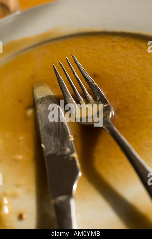 Knife and fork on an empty plate, having finished the meal the plate is cleared Stock Photo