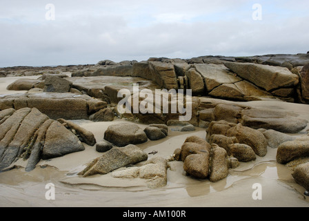 Granite rocks in tidal zone of sandy beach at the Altanic coast of Donegal on a foggy day, Ireland Stock Photo