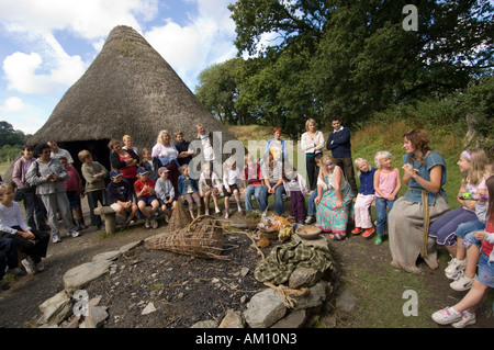 Woman in celtic dress talking about the old way of life at Castell Henllys reconstructed Iron Age hill fort Pembrokeshire wales Stock Photo