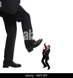 Concept image of an employee about to be stepped on by his manager Stock Photo