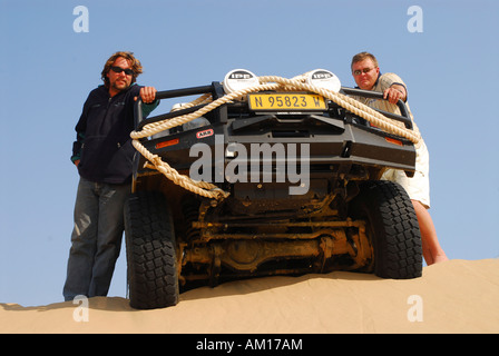 Two men with Jeep on a dune at Conception Bay, Diamond Area, Namibia Stock Photo