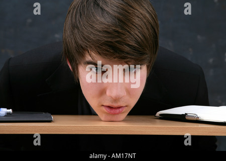 Young man resting the head on a desk Stock Photo