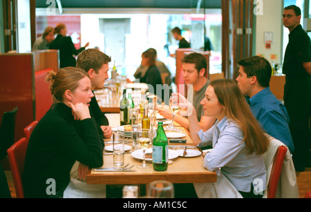 Group eating in restaurant girls chatting dinner pizza drinking friendship couples Stock Photo