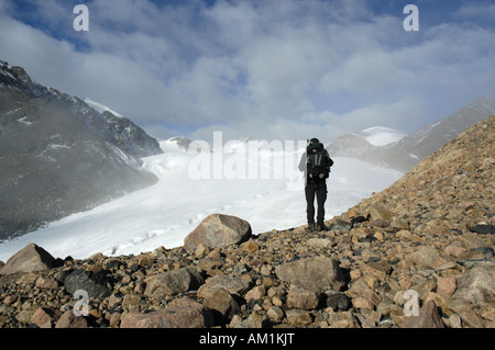Mountaineer standing on boulders in front of a glacier Kharkhiraa Mongolian Altai near Ulaangom Uvs Aymag Mongolia Stock Photo