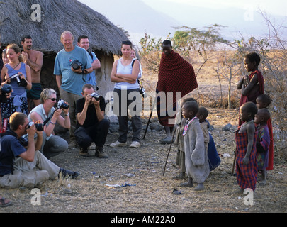 Tourists photographing the Maasai children, Tanzania Stock Photo