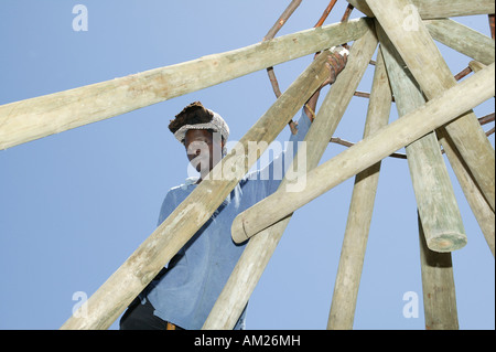 Man building a truss of a traditionial round hut, Rasta Community, Cape Town, South Africa Stock Photo