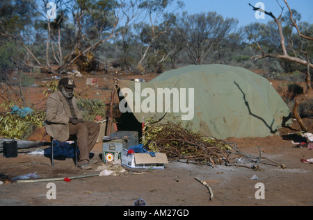 AUSTRALIA Southern Oak Valley People Australasia Ethnic Aboriginal man sat on a chair next to a green tent in an Aborigine camp Stock Photo