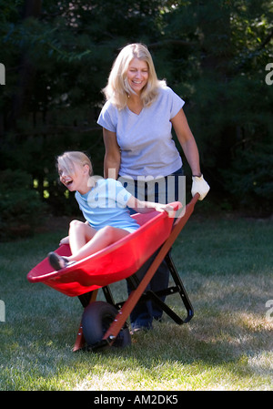 Mother carrying her daughter in a wheelbarrow Stock Photo - Alamy