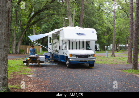 Woman cooking breakfast outside motorhome parked at Hillsborough River State Park in Florida USA Stock Photo