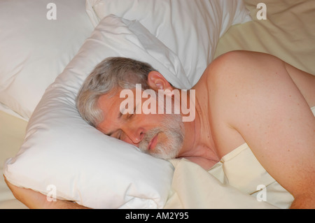 Middle aged man sleeping on the bed in a hotel room Stock Photo