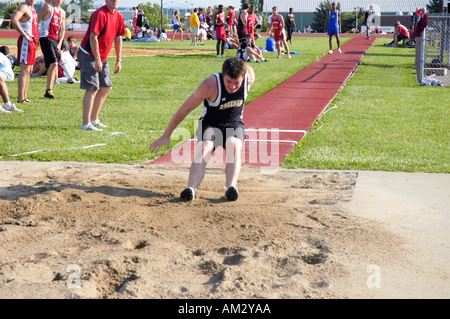 Teenage boy in the long jump at a high school track and field district meet event Stock Photo