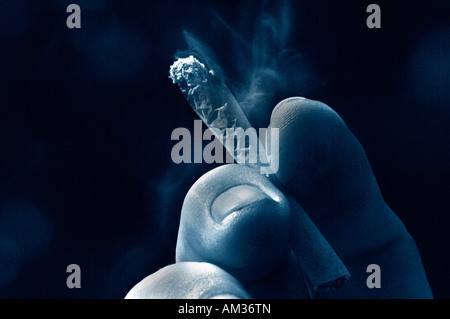 A Mans hand Holding An Unfiltered Rollup Lit Cigarette Stock Photo