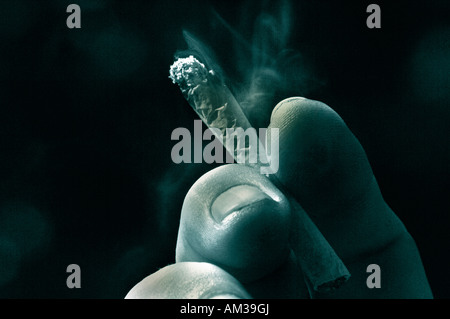 A Mans hand Holding An Unfiltered Rollup Lit Cigarette Stock Photo