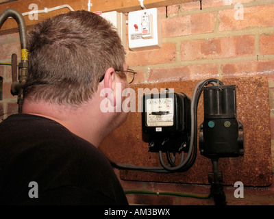 man reading and checking electric meter in garage Stock Photo