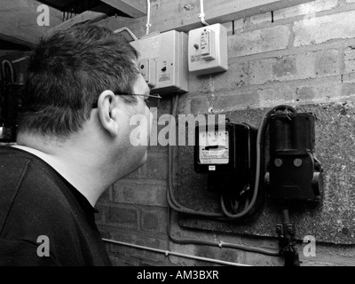 man reading and checking electric meter in garage Stock Photo