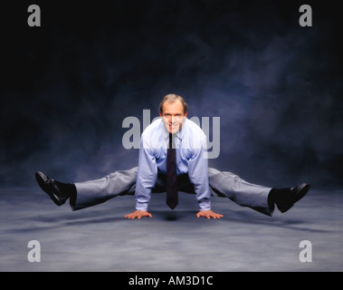 business man standing on his hands with legs spread Stock Photo