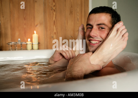 Man holding woman s feet in roll top bath Stock Photo