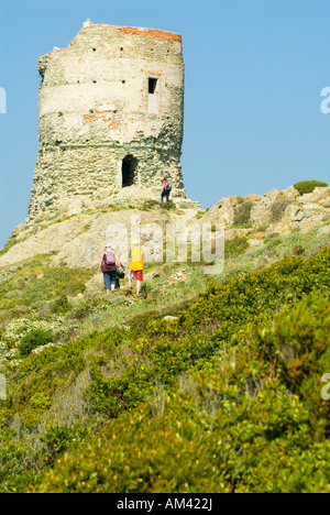 Europe, France, Corsica, Cap Corse. Family hikes through blooming maquis to Genoese Tower on Le Sentier des Douaniers Stock Photo