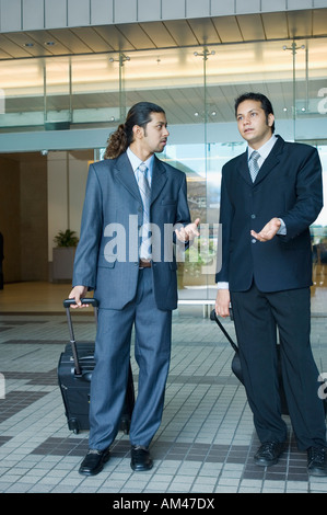 Two businessmen having a discussion at an airport Stock Photo