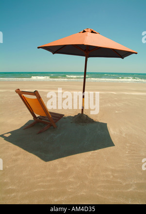 beach umbrella and chair on a sunny beach Stock Photo