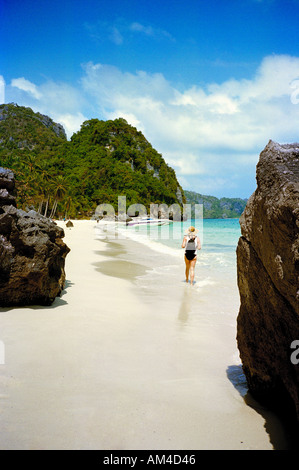 A tourist walks along an unspoilt beach on one of the islands of Ang Thong National Marine park off Koh Samui, Thailand Stock Photo