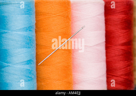 Close-up of a needle with four spools of thread Stock Photo