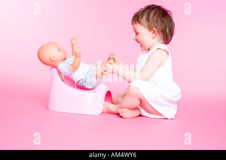 girl with doll on her toilet Stock Photo