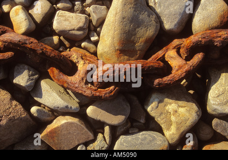 rusty old chain on a stone beach Stock Photo