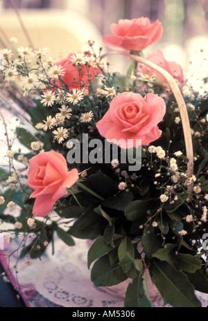 wedding flower basket of pink roses and Baby's Breath on a reception table Stock Photo