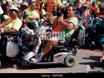 Man with disability, utilizing a scooter for mobility, filming parts of the ADAPT March on Washington Disability Advocacy event Stock Photo