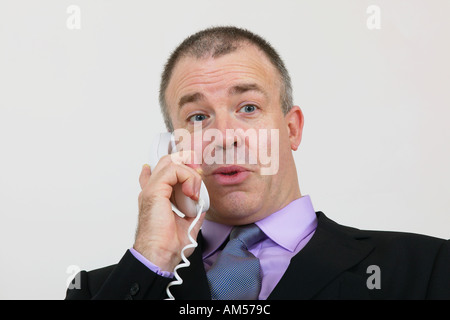Businessman having animated conversation on telephone Stock Photo