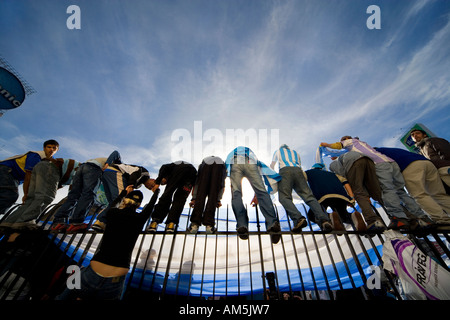 Fans climb the high steel fence around the obelisk on Plaza de La República in Buenos Aires celebrating a 6-0 victory Stock Photo