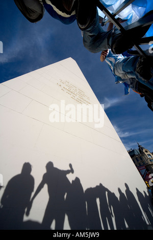 Shadows of balancing and cheering supporters fall on the white marble of the Obelisk in Buenos Aires. Stock Photo