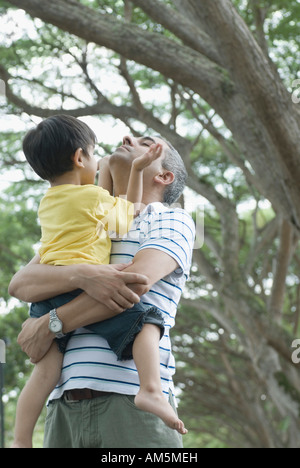Mid adult man carrying his son Stock Photo