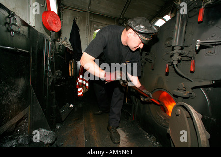 Engine driver fuelling the tank of an historical steam train Stock Photo