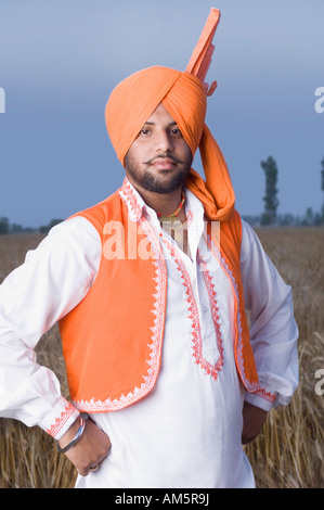 Rural man standing with his arms akimbo Stock Photo - Alamy