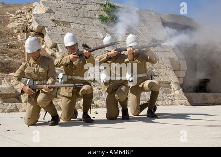 Actors dressed as soldiers in British colonial era uniforms fire a volley during a historical re-enactment at Fort Rinella, Malta Stock Photo