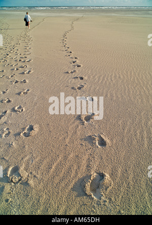 Foot prints in sand with walking person, Juist, Lower Saxony, Germany Stock Photo