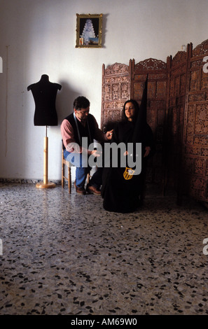 Jerez de la Frontera a tailor is taking measures for the traditional hooded costume Stock Photo