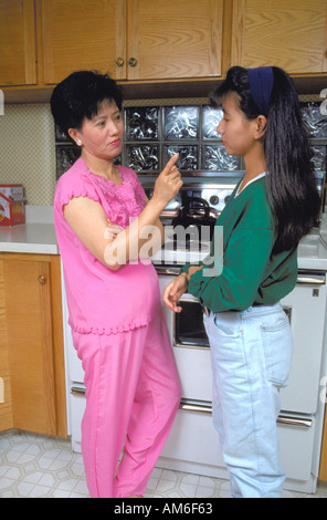 Vietnamese mother age 45 scolding 17 year old daughter. St Paul Minnesota USA Stock Photo