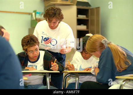 Teacher helping students in classroom ages 35 and 15. New Hope Minnesota USA Stock Photo