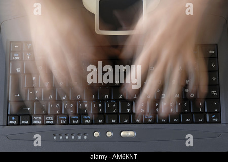 Blurred typing hands over keyboard Stock Photo