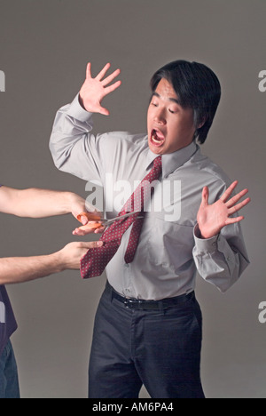 Businessman with tie being cut depicting demotion emasculation Stock Photo