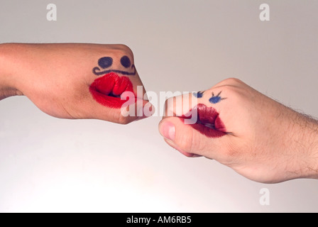 Hands with funny faces drawn on with lipstick Stock Photo