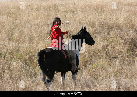 A Native American Indian riding horseback looking for ememies through the prairie of South Dakota Stock Photo
